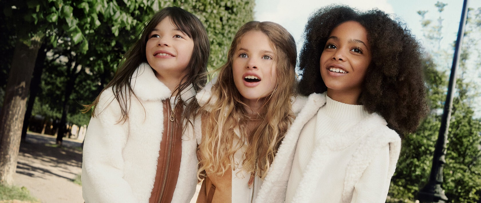 Three girls wearing Chloe clothing. One is wearing a sleeveless Chloe vest and the other two are wearing Chloe coats.