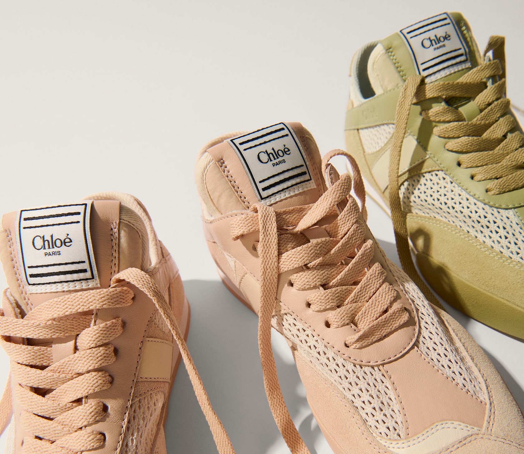 Two luxury Chloé Kick sneakers in peachy pink and soft khaki