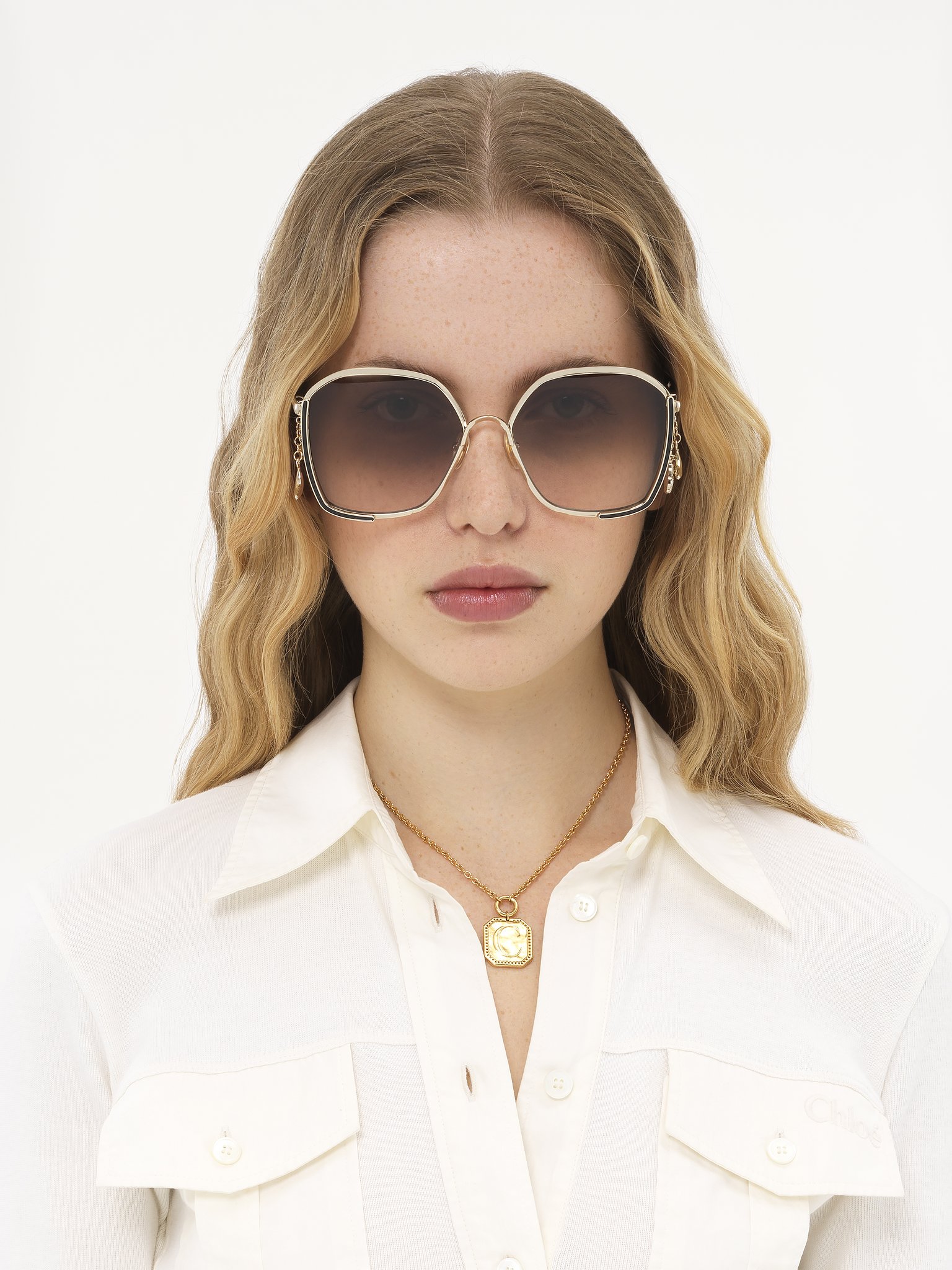 Chloé Charms sunglasses Gold metal, black enamel & bio-based nylon
Gradient brown lenses Front view of the product being worn