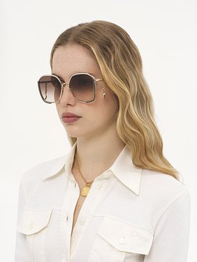 Chloé Charms sunglasses Gold metal, black enamel & bio-based nylon
Gradient brown lenses Front view of the product being worn