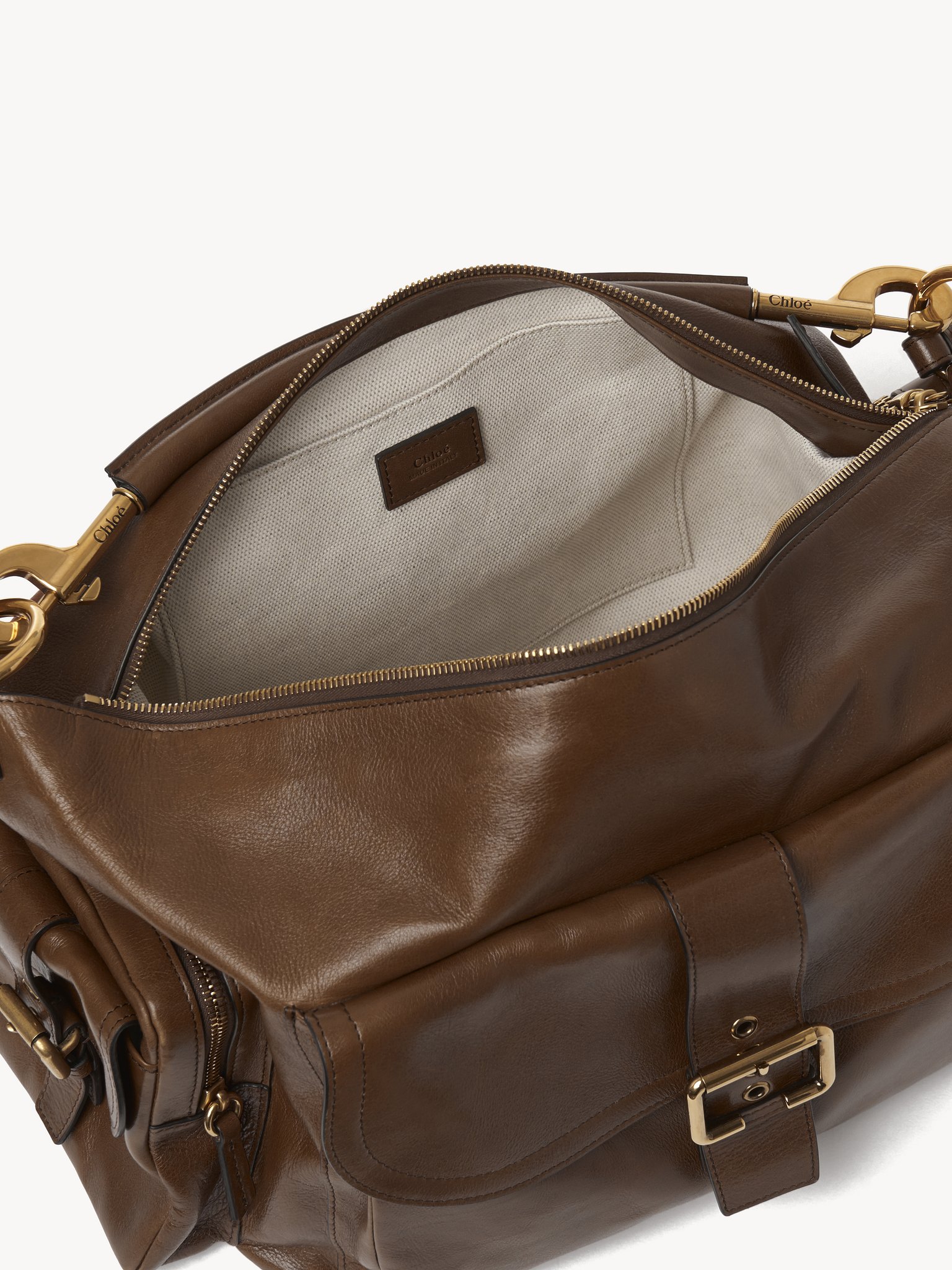 Large Camera bag in shiny leather Natural shiny buffalo leather
Dark Khaki Front view of the product being worn