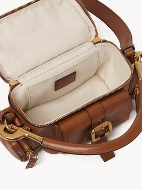 Small Camera bag in shiny leather Natural shiny buffalo leather
Clay Brown Front view of the product being worn