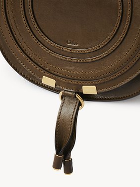 Small Marcie saddle bag in shiny leather Shiny calfskin
Dark Khaki Front view of the product being worn