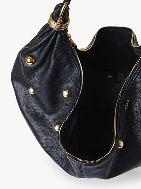 Large Bracelet Hobo bag in grained leather with studs Shiny grained calfskin with oversized studs
Evening Blue Front view of the product being worn